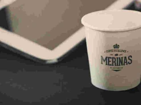 平板電腦旁邊的紙杯logo樣機